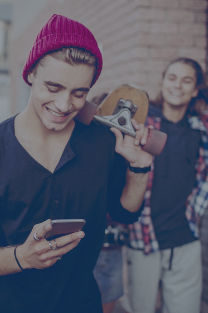 Young man with mobile phone enjoying time with friends